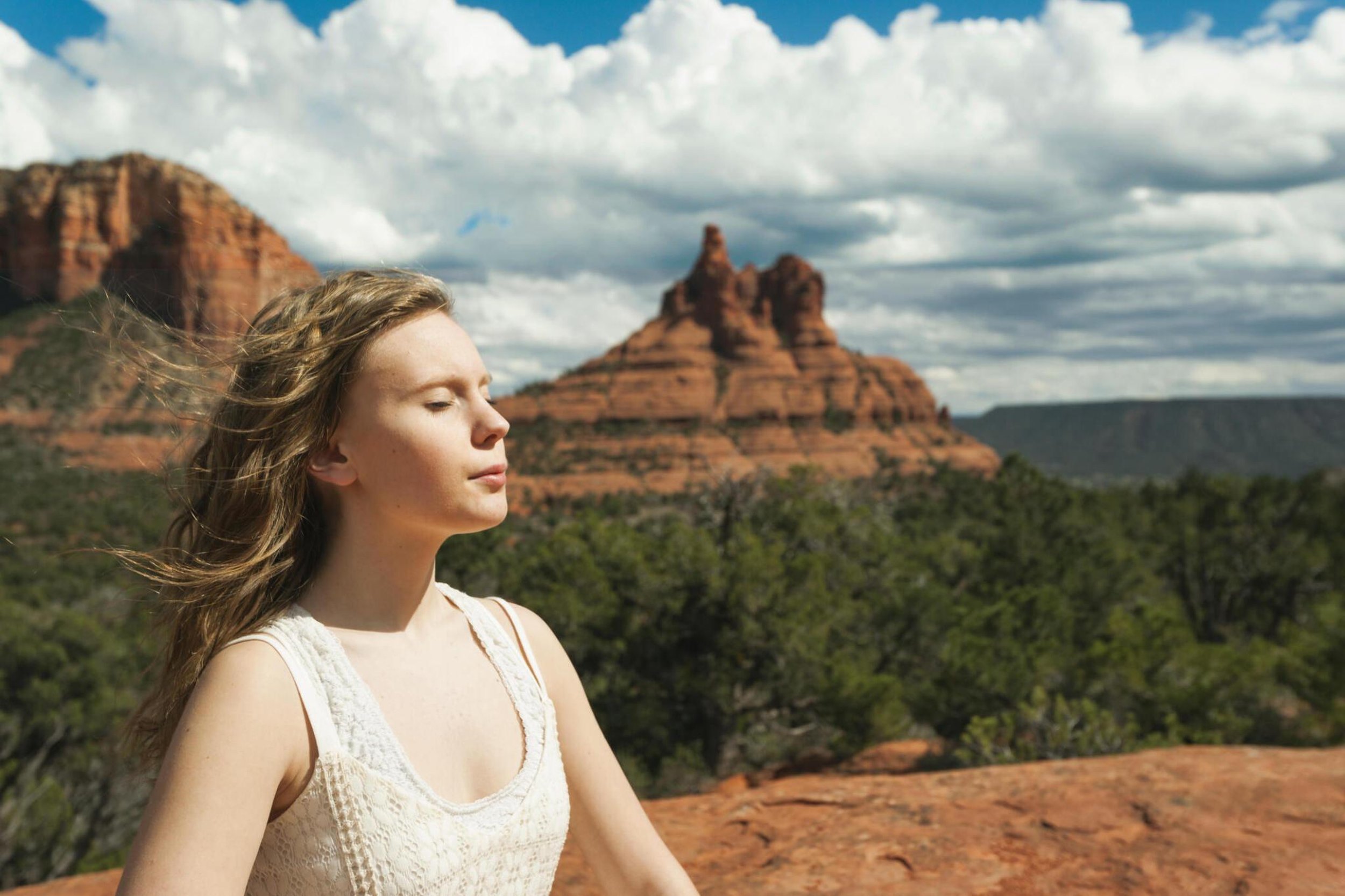 woman soaking in the sun in Sedona Arizona with Bell Rock in the background