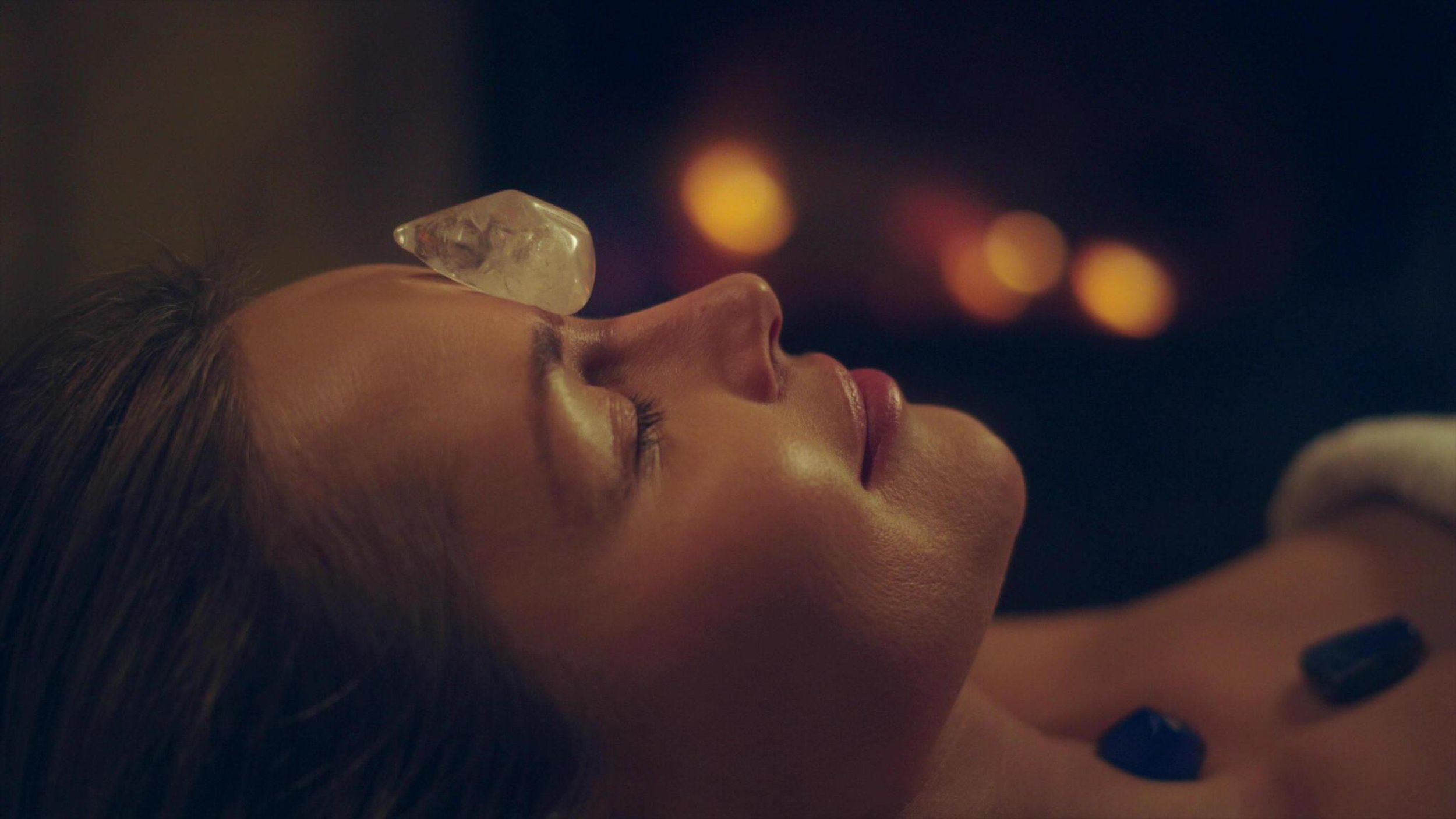 woman who is relaxing with crystals placed at strategic energetic points